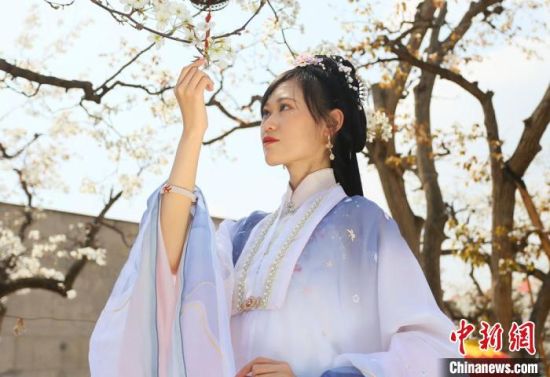 圖為蘭州青年身穿漢服在百年梨園賞景?！「哒?攝