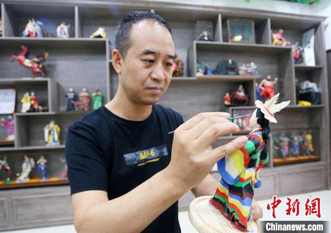 圖為安秋平正在創(chuàng)作代表隴南文縣民俗的《白馬人》作品?！「哒?攝