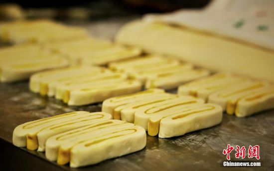 圖為面劑被涂上胡麻油，切成條狀用作月餅的花型制作。張文 攝