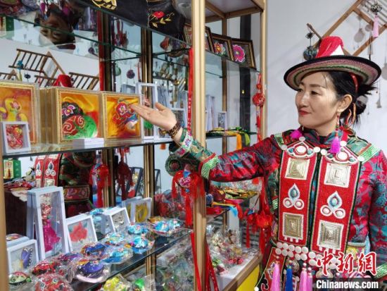 圖為身著民族服飾的隴原巧手展示手工藝品。(資料圖) 徐雪 攝