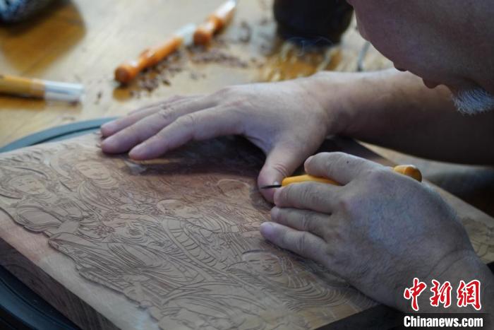 圖為徐晉林湊近木板，近距離制作雕版畫。　九美旦增 　攝