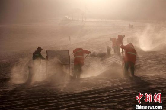 圖為敦煌市鳴沙山月牙泉景區(qū)“駱駝保姆”清理駱駝糞便?！垥粤?攝