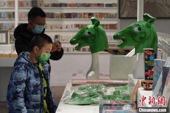 圖為“神馬來了”銅奔馬頭套吸引參觀者駐足。　九美旦增 攝