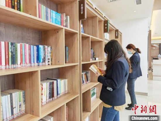 圖為在甘肅公航旅建設(shè)集團(tuán)有限公司的職工書屋，職工挑選書籍?！⌒煅?攝
