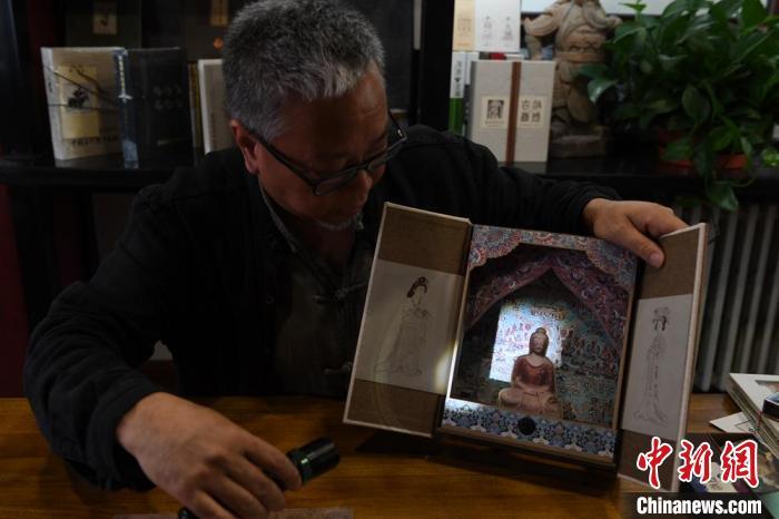 圖為讀者出版集團讀者晉林工作室獨立出品人徐晉林，展示互動性強的敦煌題材手工書。(資料圖) 楊艷敏 攝