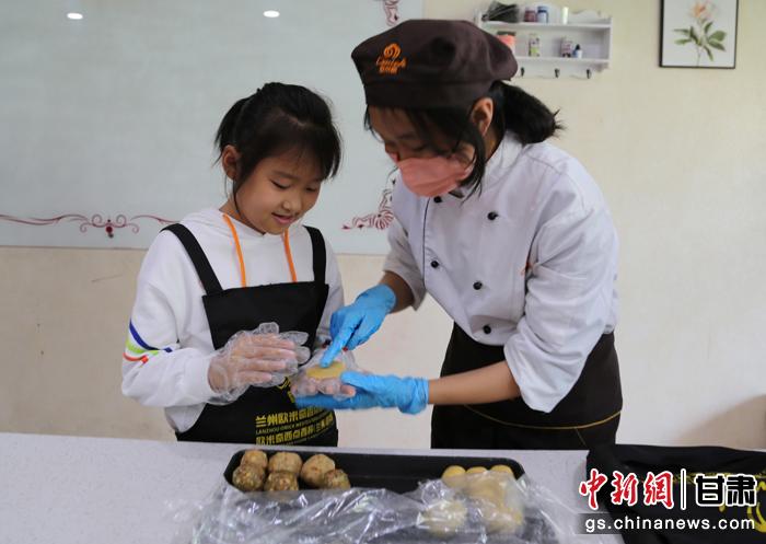 圖為在甘臺胞小朋友在工作人員指導下制作月餅。九美旦增 攝