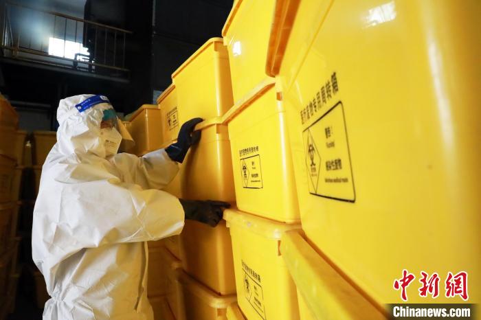 圖為工作人員搬運(yùn)醫(yī)療廢物專用周轉(zhuǎn)箱?！∥航ㄜ?攝