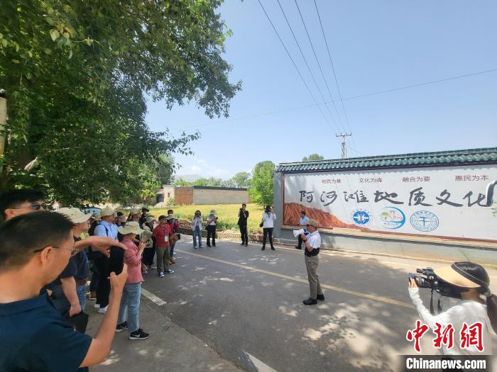 圖為中國地質(zhì)大學(xué)(北京)教授張緒教介紹村落情況?！『衍?攝