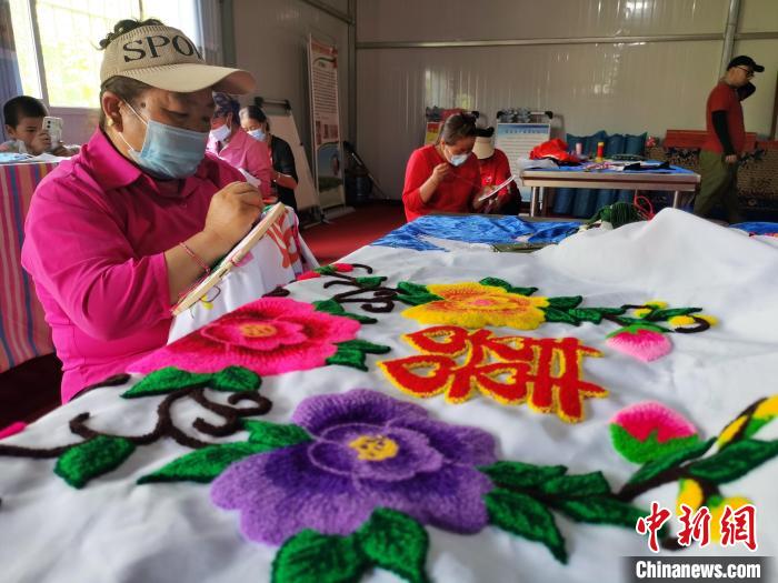 圖為婦女制作青繡?！?zhí)砀?攝