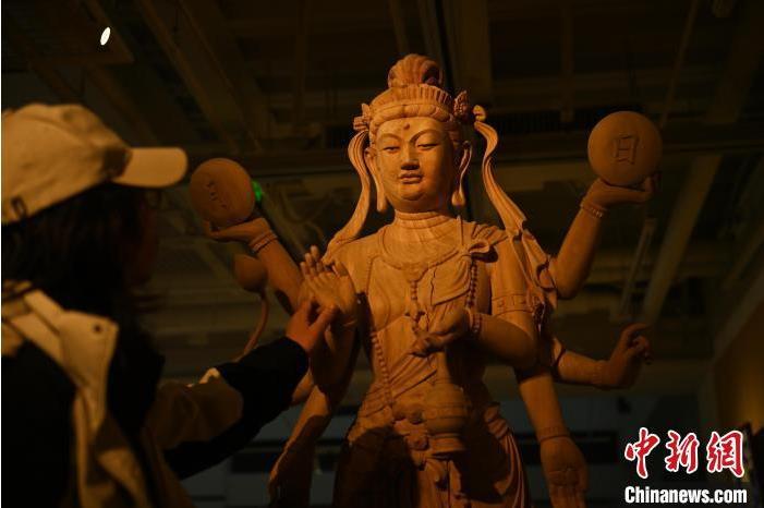 圖為季茂杰觀察自己創(chuàng)作的敦煌木雕。李亞龍 攝</p>
<p>