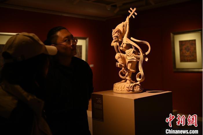 圖為季茂杰向參觀者介紹自己創(chuàng)作敦煌木雕的過程。李亞龍 攝</p>
<p>