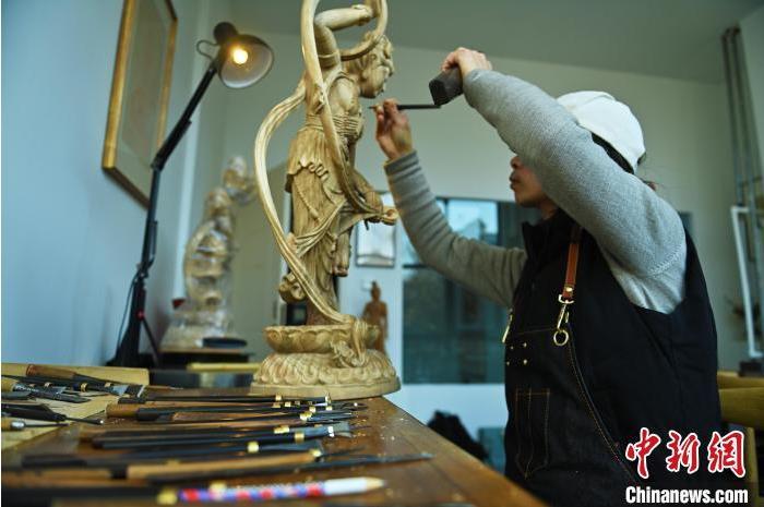 圖為季茂杰進(jìn)行敦煌元素的木雕創(chuàng)作。李亞龍 攝</p>
<p>