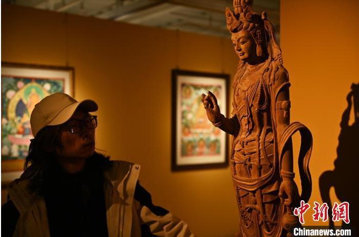 圖為季茂杰觀察自己創(chuàng)作的敦煌木雕。李亞龍 攝</p>
<p>