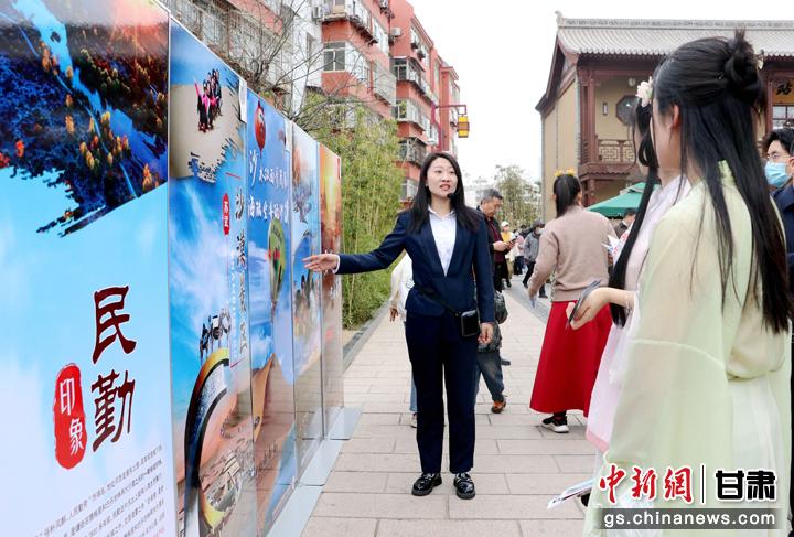 3月下旬，民勤縣在天水啟漢樓廣場舉行推介會，宣傳本地旅游資源和農特優(yōu)產品。圖為工作人員向游客介紹民勤自然風光、歷史文化。馬愛彬 攝