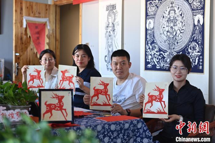 6月6日，在甘肅敦煌青年夜校課程中，青年學(xué)員展示學(xué)習(xí)敦煌非遺剪紙的成果。李亞龍 攝　　