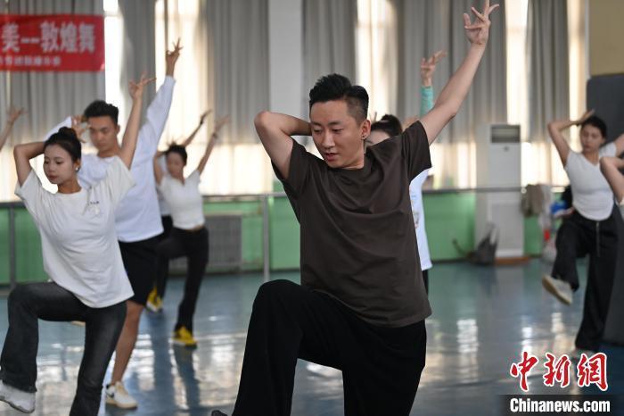 6月6日，在甘肅敦煌青年夜校課程中，青年學(xué)員學(xué)習(xí)敦煌舞課程。李亞龍 攝　　