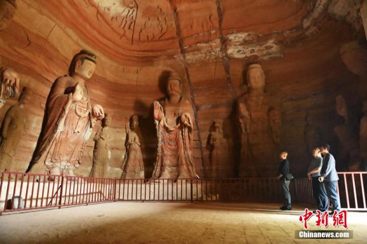 7月15日，游人參觀(guān)甘肅省平?jīng)鍪袥艽h百里石窟長(zhǎng)廊中的南石窟寺1號(hào)窟。百里石窟長(zhǎng)廊位于涇川縣境內(nèi)，由512個(gè)石窟、5眼窟中石井組成，現(xiàn)存王母宮石窟、鳳凰山石窟、南石窟寺、丈八寺石窟、羅漢洞石窟、太山寺石窟等規(guī)模較大的石窟群，還有數(shù)量眾多的小石窟群。南石窟寺開(kāi)鑿于北魏永平三年，其中1號(hào)窟屬于大型七佛窟，七佛高達(dá)6米。中新社記者 李亞龍 攝