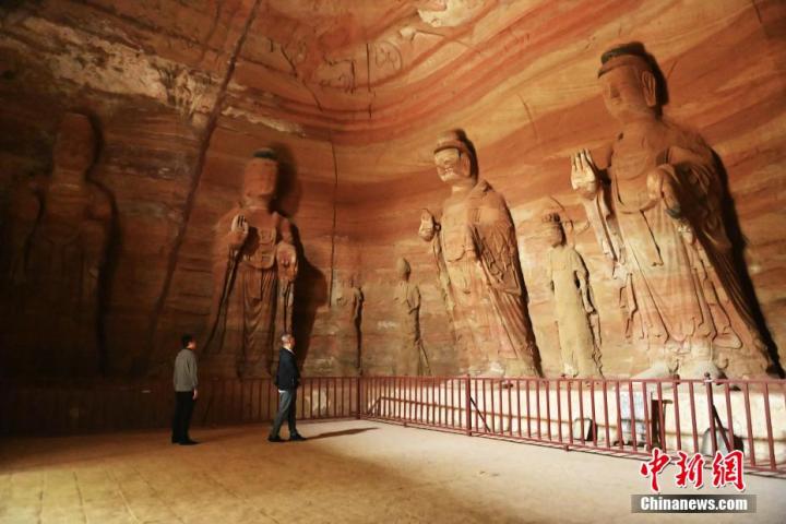 7月15日，游人參觀(guān)甘肅省平?jīng)鍪袥艽h百里石窟長(zhǎng)廊中的南石窟寺1號(hào)窟。百里石窟長(zhǎng)廊位于涇川縣境內(nèi)，由512個(gè)石窟、5眼窟中石井組成，現(xiàn)存王母宮石窟、鳳凰山石窟、南石窟寺、丈八寺石窟、羅漢洞石窟、太山寺石窟等規(guī)模較大的石窟群，還有數(shù)量眾多的小石窟群。南石窟寺開(kāi)鑿于北魏永平三年，其中1號(hào)窟屬于大型七佛窟，七佛高達(dá)6米。中新社記者 李亞龍 攝