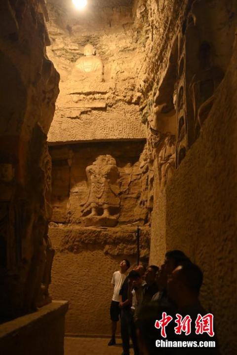 7月15日，游人參觀(guān)甘肅省平?jīng)鍪袥艽h百里石窟長(zhǎng)廊中的王母宮石窟。百里石窟長(zhǎng)廊位于涇川縣境內(nèi)，由512個(gè)石窟、5眼窟中石井組成，現(xiàn)存王母宮石窟、鳳凰山石窟、南石窟寺、丈八寺石窟、羅漢洞石窟、太山寺石窟等規(guī)模較大的石窟群，還有數(shù)量眾多的小石窟群。王母宮石窟又名千佛洞，該窟設(shè)計(jì)宏大，造像生動(dòng)，窟內(nèi)擁有造像數(shù)百尊，是較為珍貴的佛教文化遺存。中新社記者 李亞龍 攝</p>
<p>