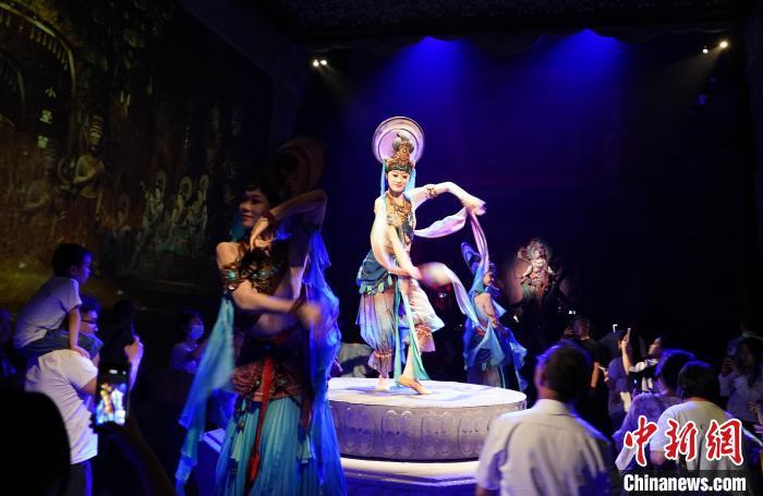 《樂(lè)動(dòng)敦煌》是全球首部洞窟式沉浸體驗(yàn)劇，利用真人與數(shù)字影像虛實(shí)交換實(shí)現(xiàn)沉浸式體驗(yàn)。圖為2023年8月28日晚，《樂(lè)動(dòng)敦煌》演出。(資料圖)中新社記者 毛建軍 攝